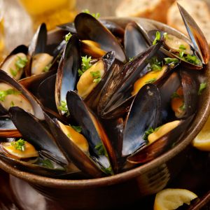 Moules Marinières, or Sailor's Mussels, is a classic French dish where mussels are cooked in a white wine and shallot broth, often enhanced with herbs and garlic.