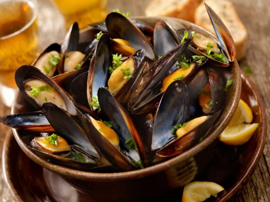 Moules Marinières, or Sailor's Mussels, is a classic French dish where mussels are cooked in a white wine and shallot broth, often enhanced with herbs and garlic.