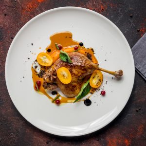 Confit de Canard is a celebrated French dish where duck legs are slowly cooked in their own fat, resulting in tender, flavorful meat with a crisp, golden skin.